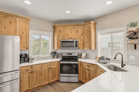 Fully stocked kitchen with appliances such as a refrigerator, oven, microwave, stove top, dishwasher, and Kuerig coffee maker.