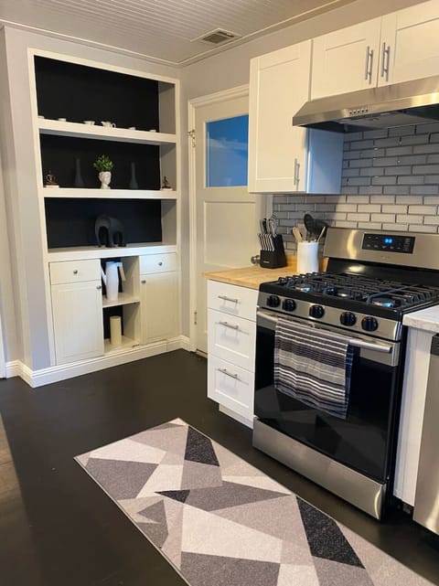 Fully equipped kitchen with gas stove and open shelving