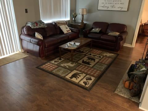 Cozy, warm & comfortable living area with a couch, loveseat & remotes/guides