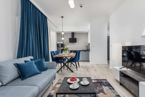 A cosy living room with a grey sofa bed and a large flat-screen TV for evening entertainment. 