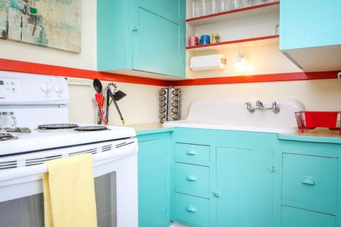 Darling kitchen with electric stove, microwave, Keurig, and an option to purchase wine.