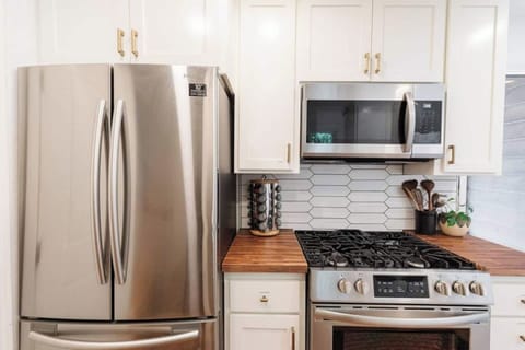 New stainless refrigerator and gas stove.