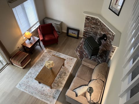 Light-filled cozy living room with wood-burning stove. Pic taken from upper loft