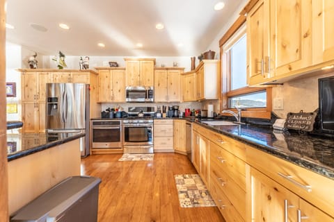 Spacious updated kitchen with modern stainless steel appliances, granite countertops and small flat screen TV.