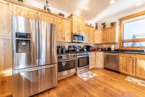 Spacious updated kitchen with modern stainless steel appliances, granite countertops and small flat screen TV.