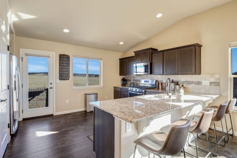 Spacious kitchen with granite countertops, gas stove, microwave, dishwasher.