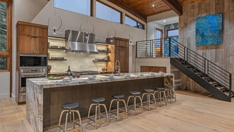 Gourmet kitchen with 6-burner gas range, 3 dishwashers, and bar seating for 7
