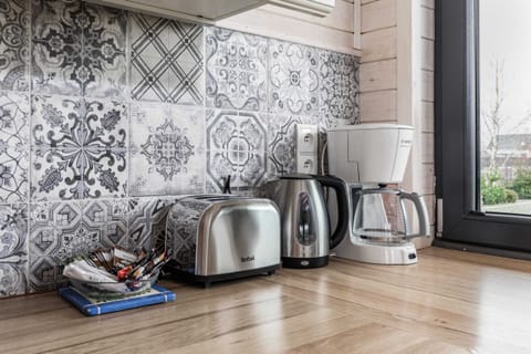Kitchen corner with a wicker tray of coffee essentials, an electric kettle, and a clean countertop. Ideal for a quick breakfast or tea break.