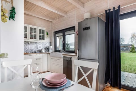 A view of the white dining room with the kitchenette in the background.