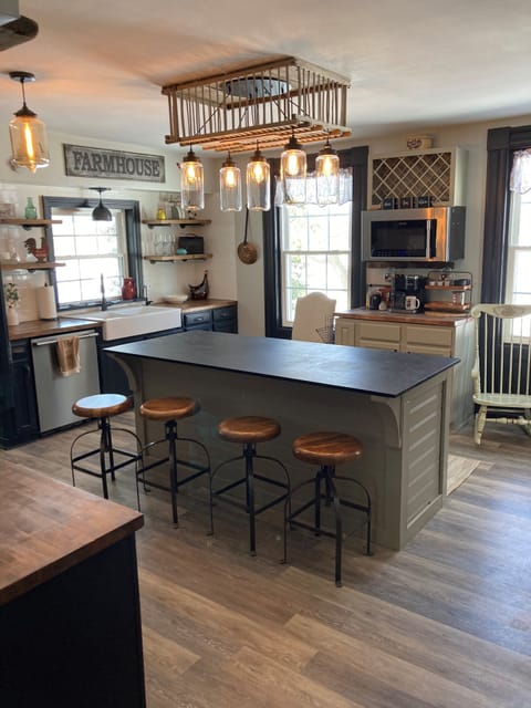 Modern kitchen- island, stove, microwave, keurig drip and cup, farm house sink