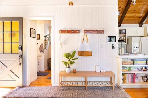 Front entrance, main floor bathroom, and entryway bench with coat rack.