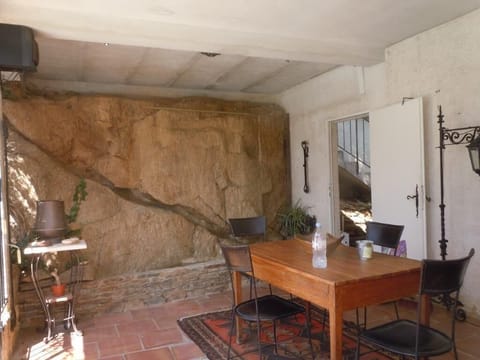 Back covered terrace with fountain built in the rock wall - looks out at pool