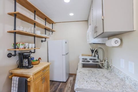 - Efficient kitchenette equipped with microwave, electric stove, and full fridge
- Rustic industrial shelves keep essentials within easy reach for your morning brew
- Thoughtful touches like a coffee station and wood style flooring add cozy flair