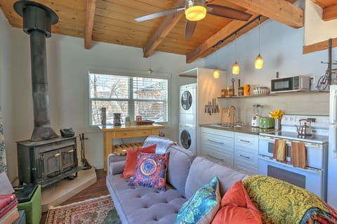 Open living and kitchen area with wood burning stove and full washer and dryer