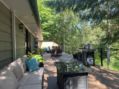 Large deck with multiple seating areas overlooks creek