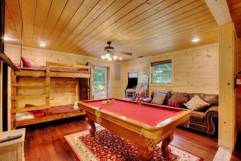 Enter in the side door that opens up to the game area of the downstairs living space. Game area includes an arcade with hundreds of games, pool table, large flatscreen TV, and a twin bunk bed, with a full bathroom and laundry off this room.