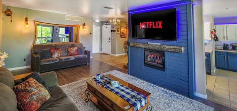 Living Room: Unwind by the fireplace and 65″ Smart TV in a Cozy open layout. 