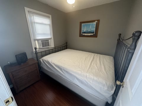 Bedroom with queen sized bed, ceiling fan and window AC 