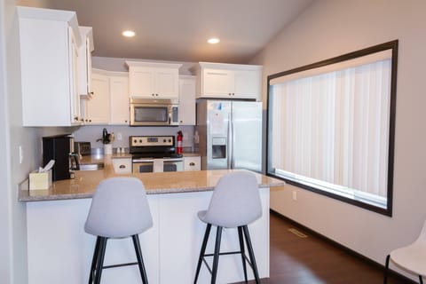 Kitchen breakfast bar has 2 bar stools making 8 seats available for dining