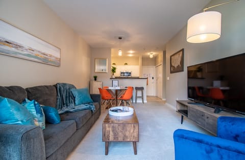 Spacious living room with a 65" tv, sleeper sofa and beautiful garden views