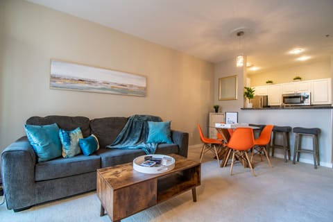 Spacious living room with a 65" tv, sleeper sofa and beautiful garden views