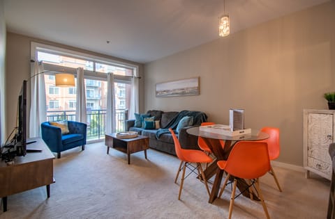 Spacious living room with a 65" tv, sleeper sofa and beautiful garden views