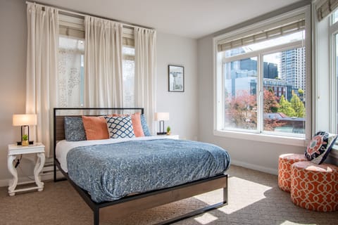 Comfortable queen bed in a spacious sun filled bedroom with water views.