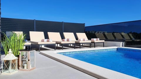 A heated pool, sun loungers