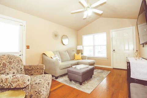 Pedal Inn One.  Living area has a sofa with a chaisse lounge, ottoman stores extra throws and a big, comfy chair. 