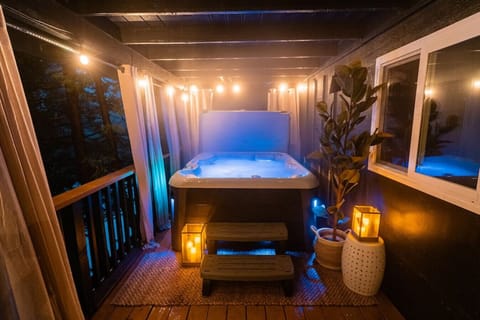Soothe your senses in this tranquil hot tub haven, surrounded by twinkling string lights