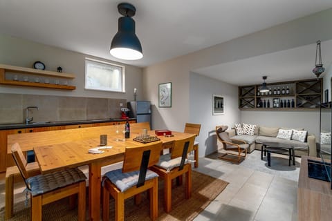 A kitchenette with a fridge, Table tennis, Darts, PS5, flat-screen TV, a table and comfortable sofa