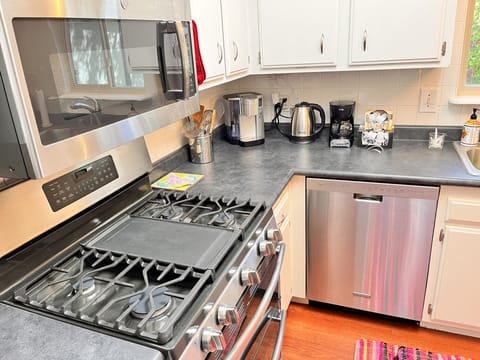 Kitchen counter with kettle, and keuring, and coffee pot.