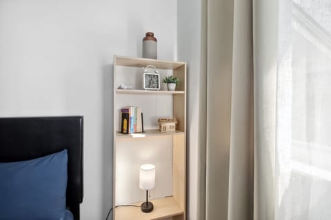 "Cozy bedroom with a comfortable queen bed, soft lighting, and ample natural light from large windows. Perfect for a restful night’s sleep."