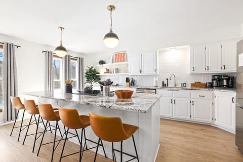 This space features a large granite island with five barstools.