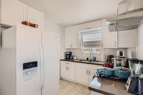 Enjoy the full kitchen with a refrigerator, oven, stove, microwave, coffee, creamers, mixers, spices, pots, pans, cooking supplies, cutlery, cups, plates, bowls, utensils, small appliances, view of the backyard, and many more essentials.