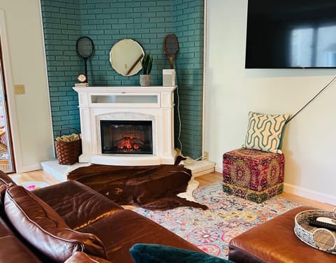 first floor livingroom with large leather sectional and cozy fireplace