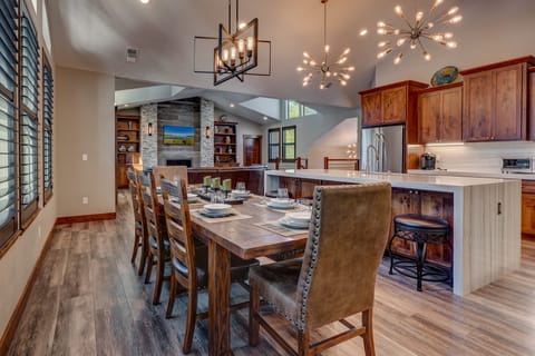 - Dining room with large rustic table and seating
- Overlooks kitchen and living area with fireplace
- Open-concept design for family meals and gatherings