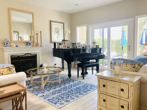 Living Room with baby grand piano and gas fireplace. 