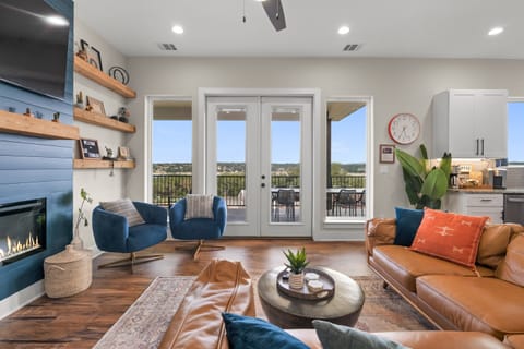 The professionally decorated living room features hues in blue and burnt orange.