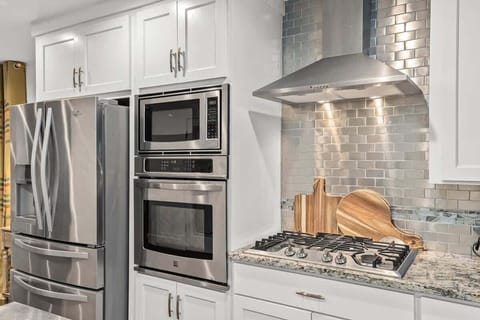 Fully equipped kitchen stocked with utensils & cookware.