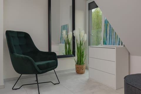 Armchair, chest of drawers and mirror in the bedroom.