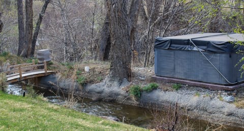 Bubbly hot tub just across the bridge with amazing views of the wooded area and creek.
