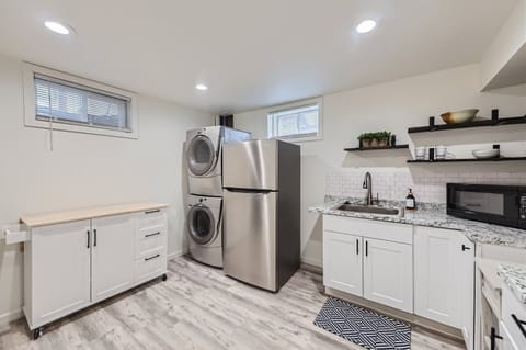 Utility room with washer and dryer, sink and second refrigerator.