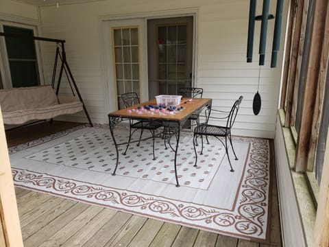 Screened-in porch with game table and chairs