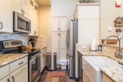 Full size kitchen with granite countertops and stainless steel appliances.