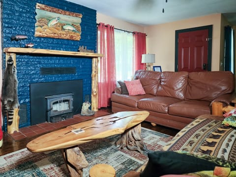 The living room has comfortable leather seating with fishing decor.