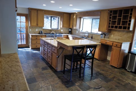 Gourmet kitchen with double ovens, gas rangetop, spacious countertops, & island
