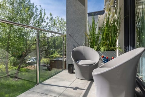 Furnished balcony with green surroundings. 