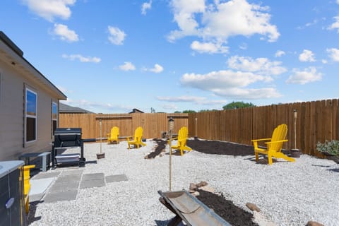 Unwind by the fire pit with friends under Texas skies, complete with seating and privacy fencing.