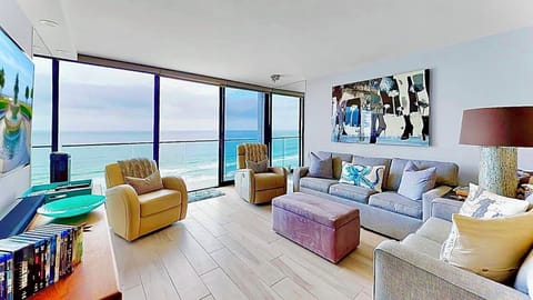 Living room w/floor to ceiling windows overlooking the beach and Pacific Ocean.